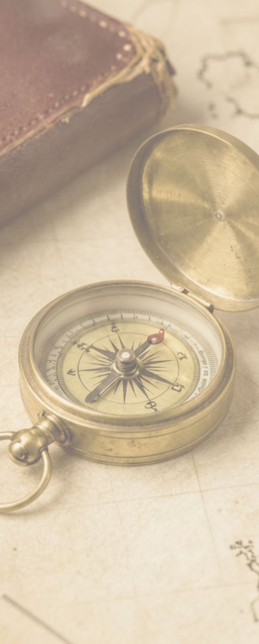 Brass compass resting on an old map